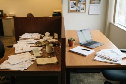 Escritorio de oficina con laptop, documentos y calculadora, sin personas